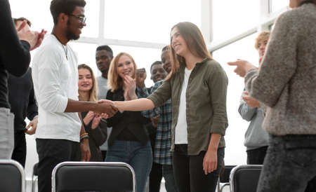 group of happy young people congratulating their colleagueの写真素材
