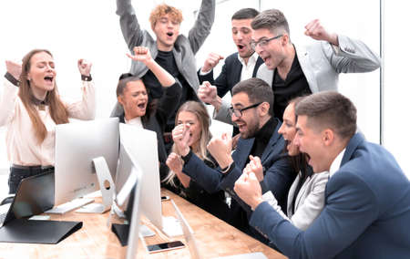 exultant business team looking at the screen of the office computerの写真素材