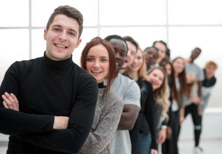 young man standing in front of a group of young peopleの写真素材