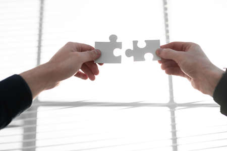 two 2 hands trying to connect couple puzzle piece