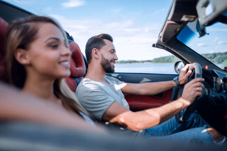 close up.smiling couple sitting in a convertible car