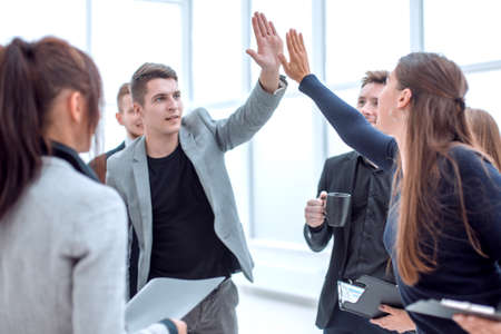young employees giving each other a high fiveの写真素材