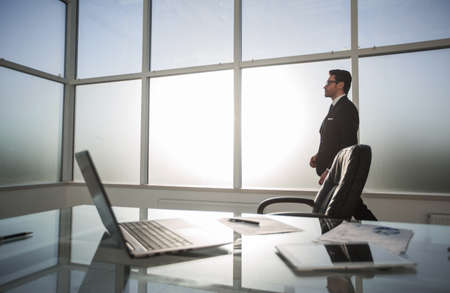 Businessman standing and looking out the window in the conference room