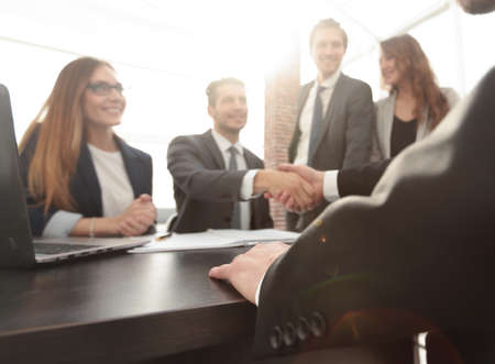 shaking hands after a business meeting in the office