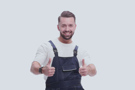 in full growth. friendly man in overalls showing thumbs upの写真素材