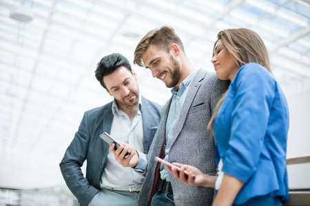 close up.business colleagues reading a text on smartphonesの写真素材