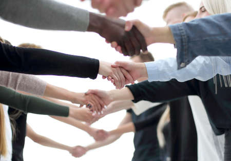 background image of diverse young people shaking handsの写真素材