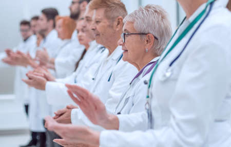 large group of medical practitioners applauding together.
