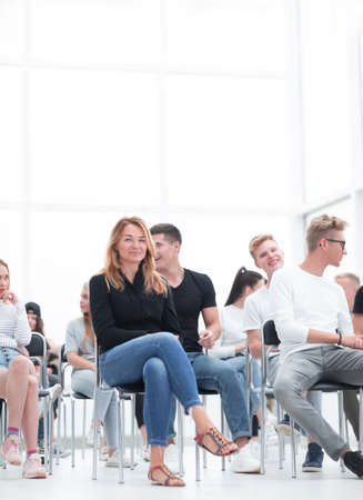 young woman sitting among the listeners of the business seminarの写真素材