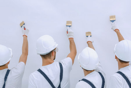 rear view.construction workers paint the wall.の写真素材