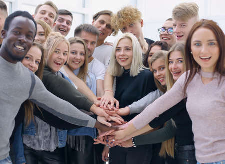 group of young people making a tower out of their hands
