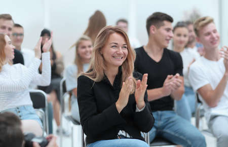close up. smiling young woman applauding sitting in conference r