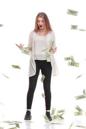 Exciting beautiful woman on white background with hundred dollars bills falling around herの写真素材