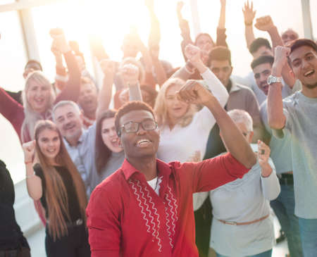 multinational group of happy people standing with their hands up.