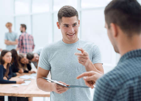 two young employees discussing a business document
