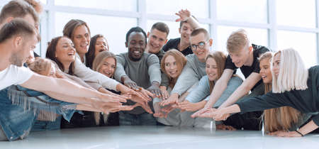 multinational group of young people joining their palms