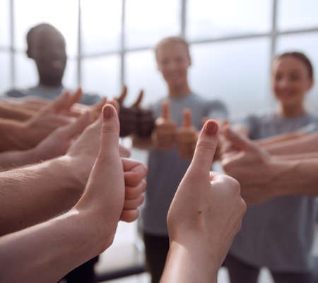 close up. group of young people showing thumbs up.
