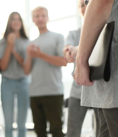 blurred image of a group of young people sitting in a circle