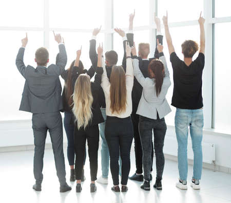 rear view. groups of young business people pointing up .