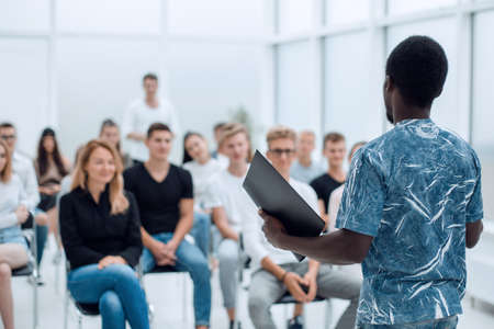 group of young people sitting on the floor and looking at the camera.