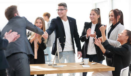 two young women shaking hands near an office Desk.の写真素材
