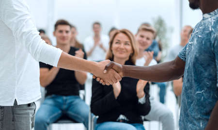 young men shake hands before the start of the briefing