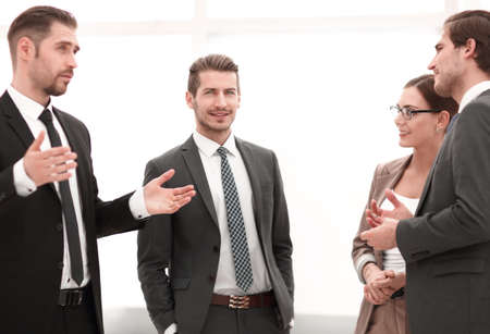 businessman talking to his colleagues standing in the office.の写真素材