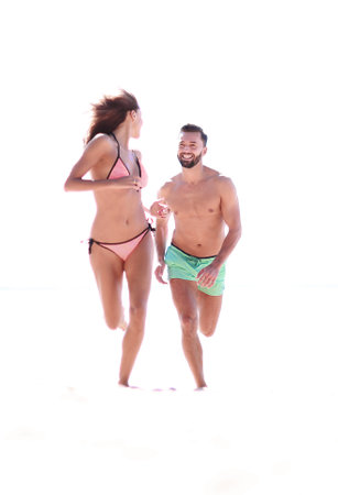 Couple having fun running throughsand on beach.の写真素材