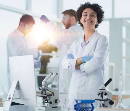 Smiling scientists looking at camera arms crossed in laboratoryの写真素材