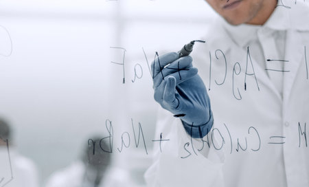 serious scientist writes a formula on a glass Boardの写真素材