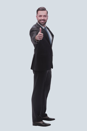 full length . successful businessman showing thumbs upの写真素材