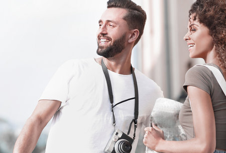 Young couple walking and looking at a guide while looking happyの写真素材