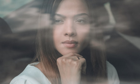 thoughtful business woman sitting in car backseatの写真素材
