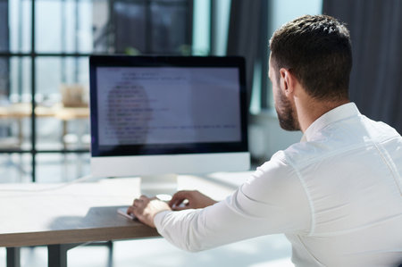 Young business man working at home with laptop and papers on desの写真素材