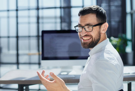 Young employee looking at computer monitor during working day in