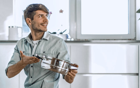 young man looking at clean dishes in dishwasherの写真素材