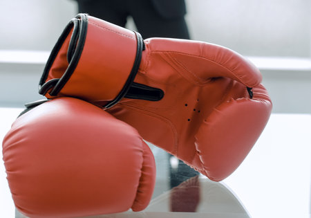 Boxing gloves on the businessmans desktopの写真素材