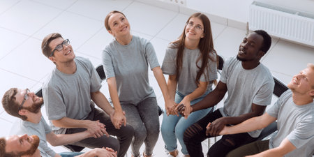young people holding each others hands at a group meeting.の写真素材