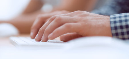 close up. a man works on an office computer.