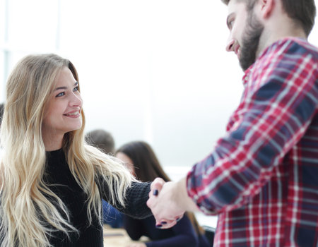 happy business colleagues shaking hands with each otherの写真素材