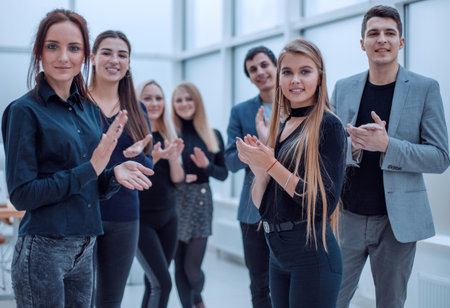 young employees applauding together standing in the office .の写真素材