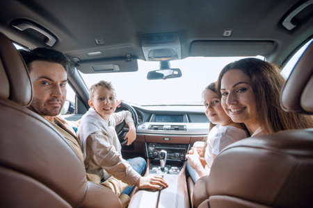 cheerful family sitting in the carの写真素材