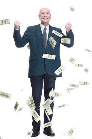 happy business man standing in the rain of dollar bills.の写真素材