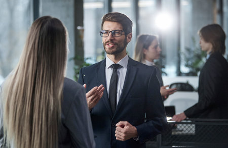 A man and a woman are talking in a business setting