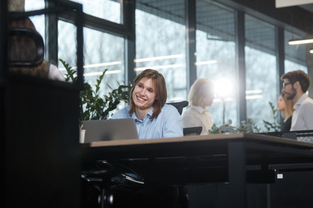 A group of people are sitting at desks in an officeの写真素材