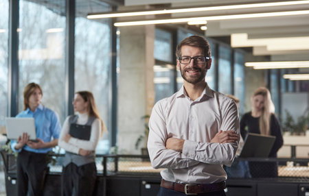 A man stands in front of a group of people in a business setting