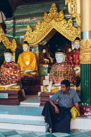 Yangon, Myanmar - FEB 19th 2014: Burmese male are sitting in front of temple at Shwedagon Pagodaのeditorial素材