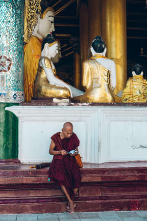 Yangon, Myanmar - FEB 19th 2014: Monk are reading in front of temple at Shwedagon Pagodaのeditorial素材