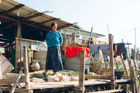 Inle Lake, Myanmar - FEB 25th 2014: Burmese female stand outside wooden houses on piles inhabited by the tribe of Intharのeditorial素材