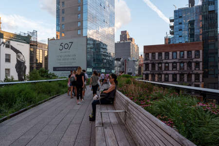 New York NY - USA - Jul 24 2019: The High Line Park in New York with locals and tourists. The High Line is a popular linear park built on the elevated train tracks above Tenth Ave in New York Cityのeditorial素材